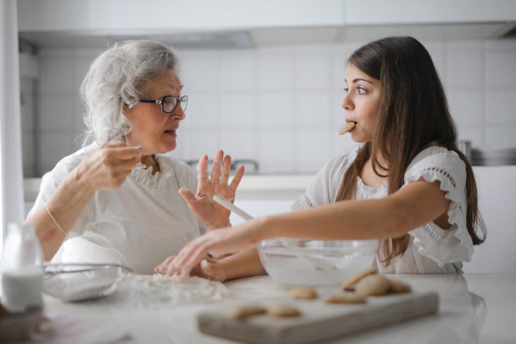 old woman and a girl eating and baking together